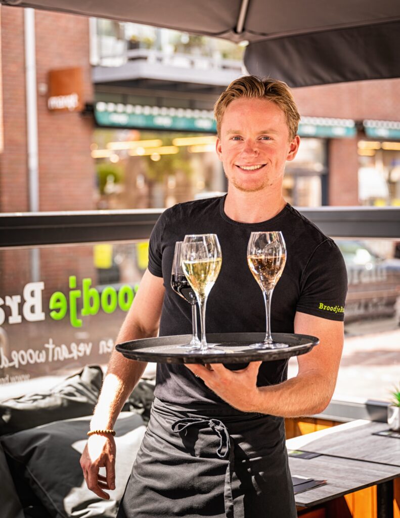 Bediening schenkt wijn aan tafel